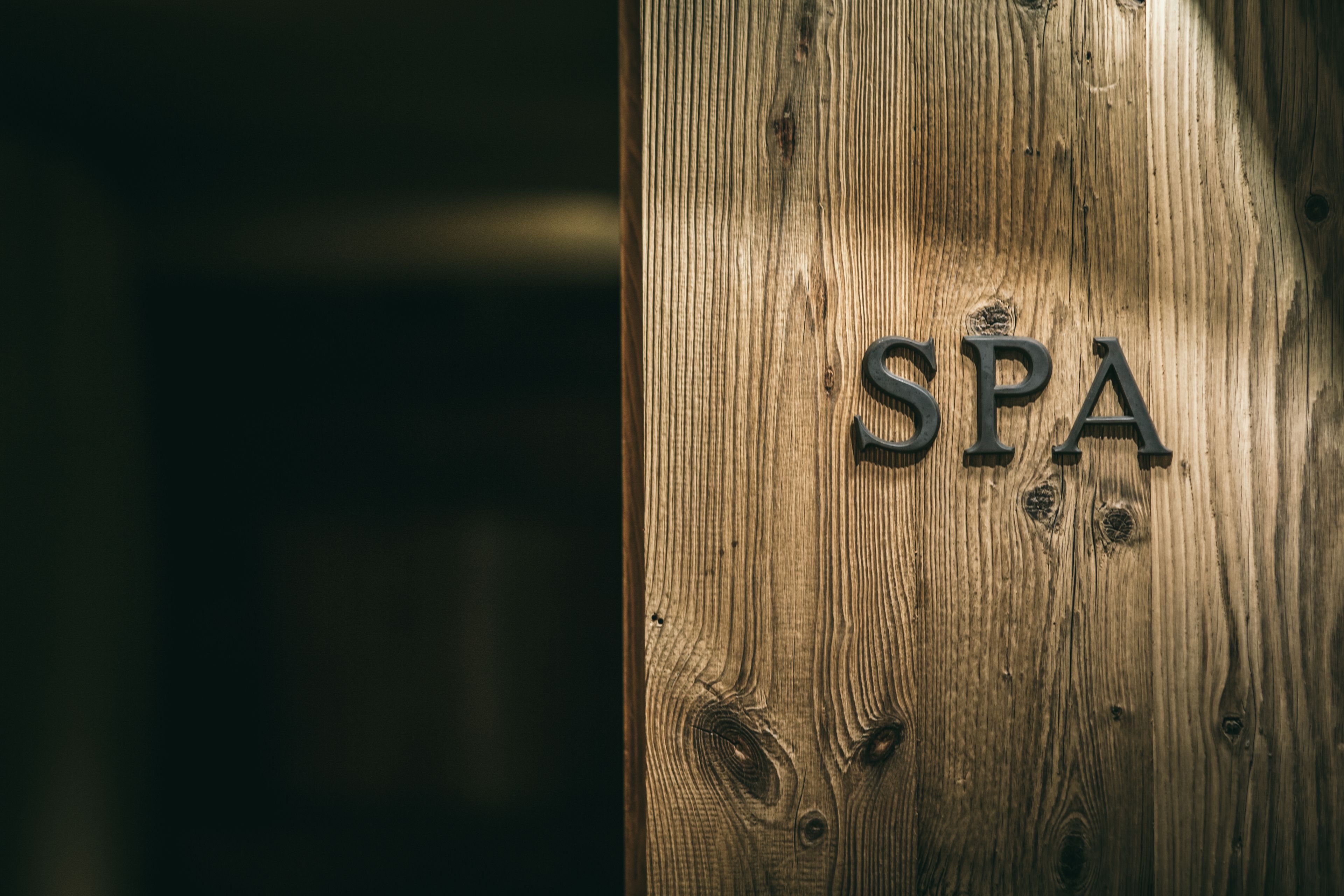 Una puerta de madera con las letras “SPA” en relieve.