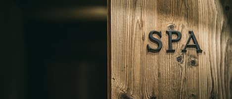 Una puerta de madera con las letras “SPA” en relieve.