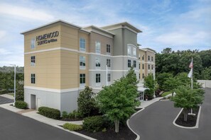 A multi-story hotel building with a sign reading 'HOMEWOOD SUITES by Hilton.'