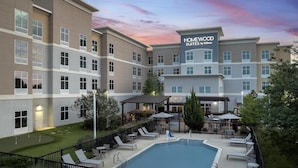 Un hôtel doté d’une piscine, d’un espace extérieur aménagé et d’une enseigne indiquant qu’il s’agit d’un établissement Homewood Suites by Hilton.