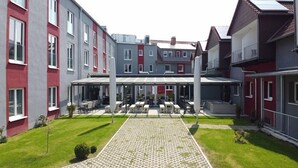 A courtyard with outdoor seating, a covered area, and a patterned walkway. - Adesso Hotel Göttingen (Goettingen)