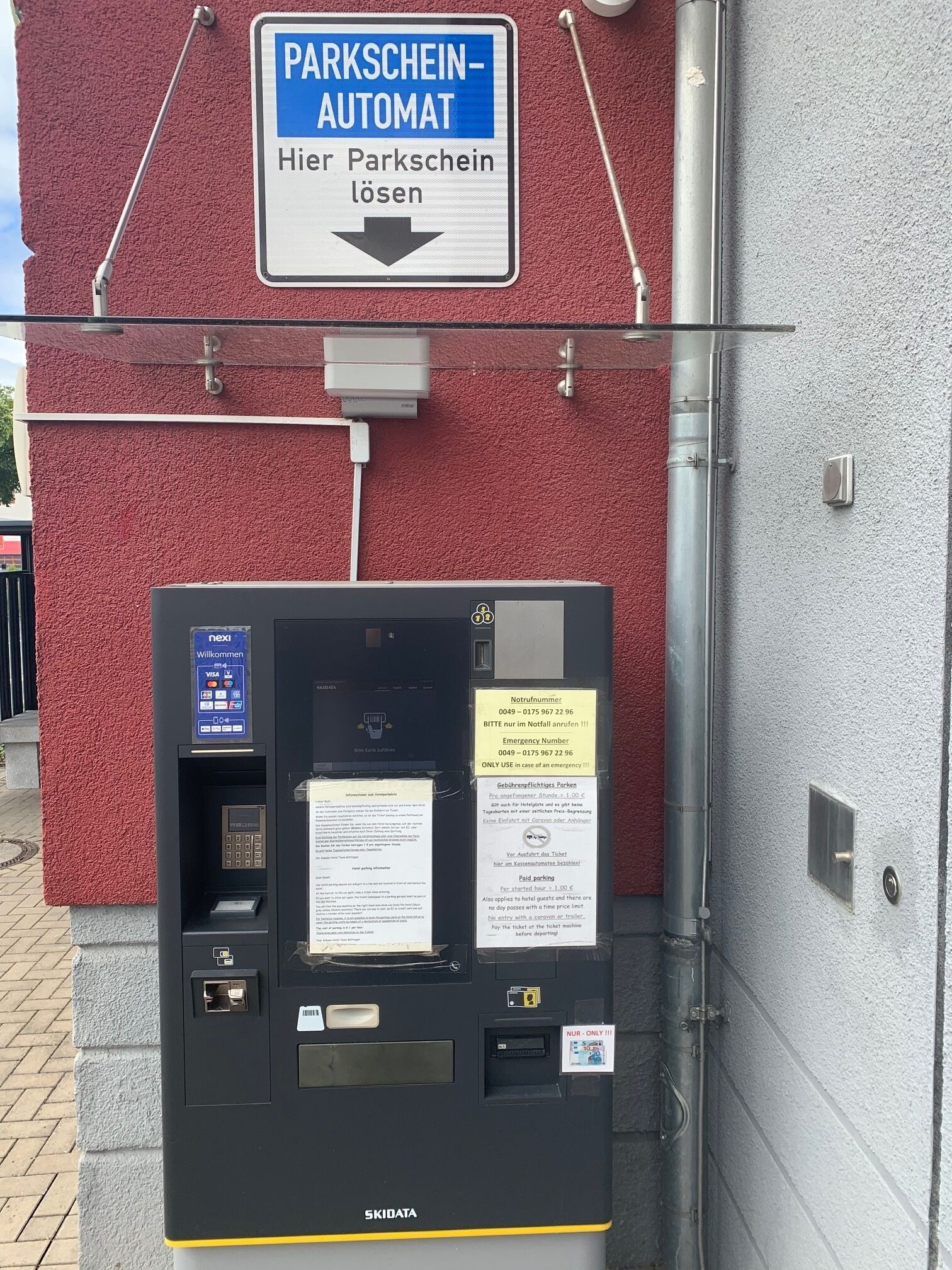 Un parquímetro con un letrero encima que dice 'PARKSCHEIN-AUTOMAT' y 'Aquí se resuelven los tickets de estacionamiento'.