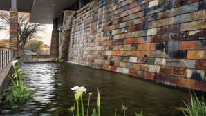 A modern building with a water feature and stone wall. - Premier Hotel Midrand (Midrand)