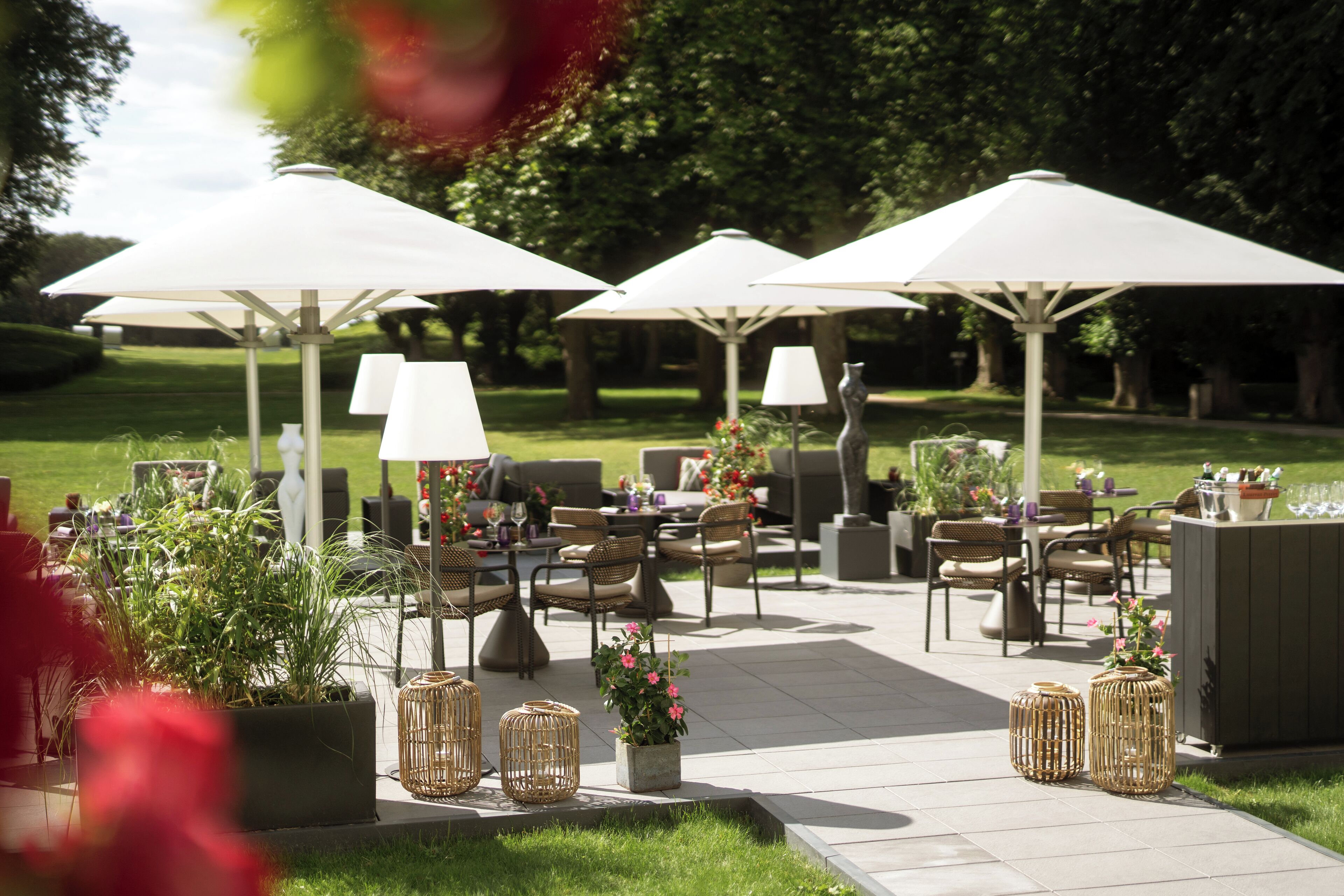 An outdoor patio area with seating, umbrellas, and potted plants.