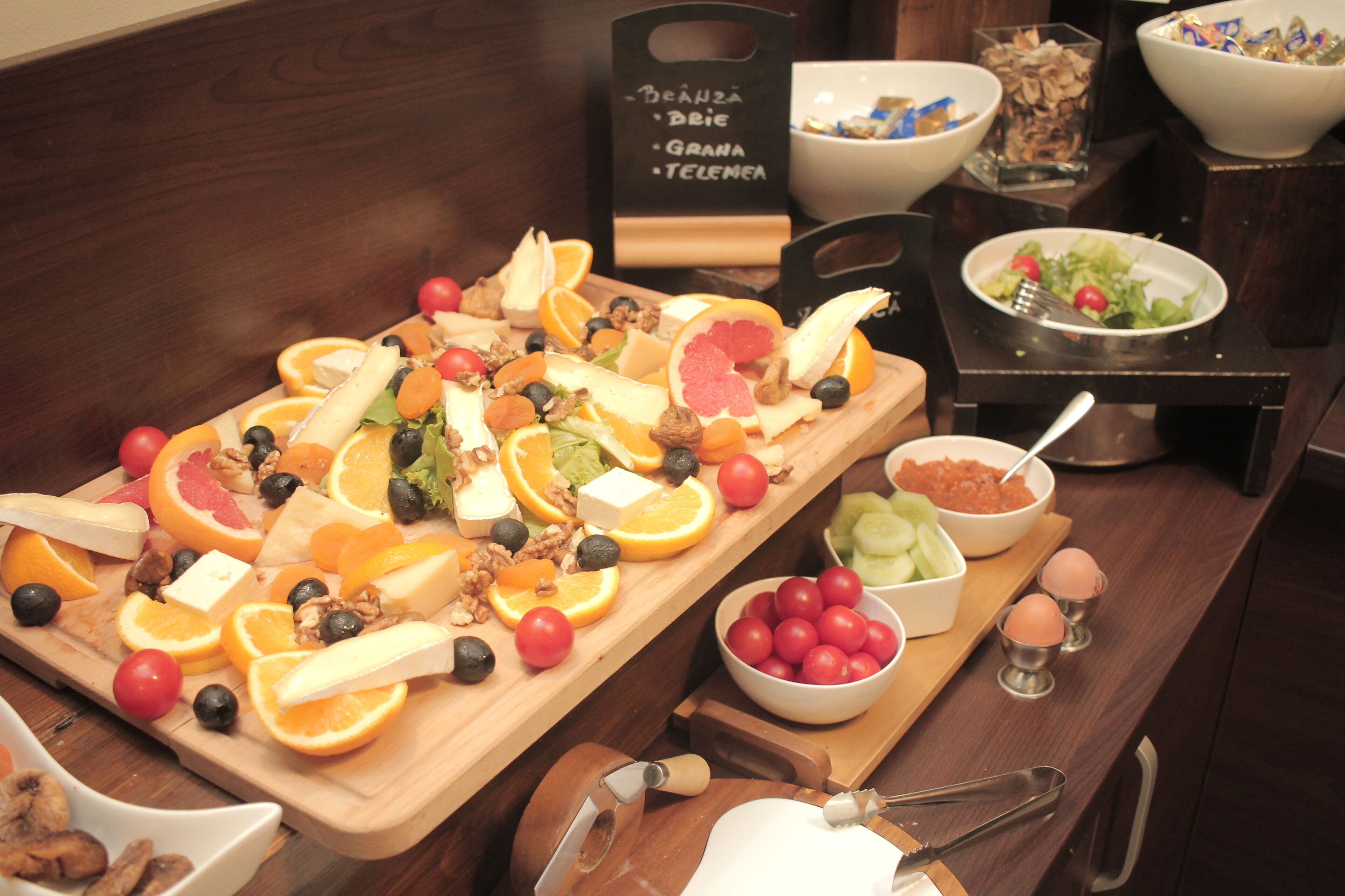 Een ontbijtbuffet met diverse soorten fruit, kaas en brood.