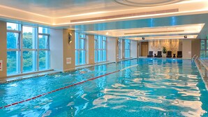 An indoor swimming pool with clear water, multiple lanes, and large windows offering views of the outdoors. - Junluxe Hotel Guangzhou Science City-Free Shuttle Bus Service to Guangzhou Canton Fair (Guangzhou)