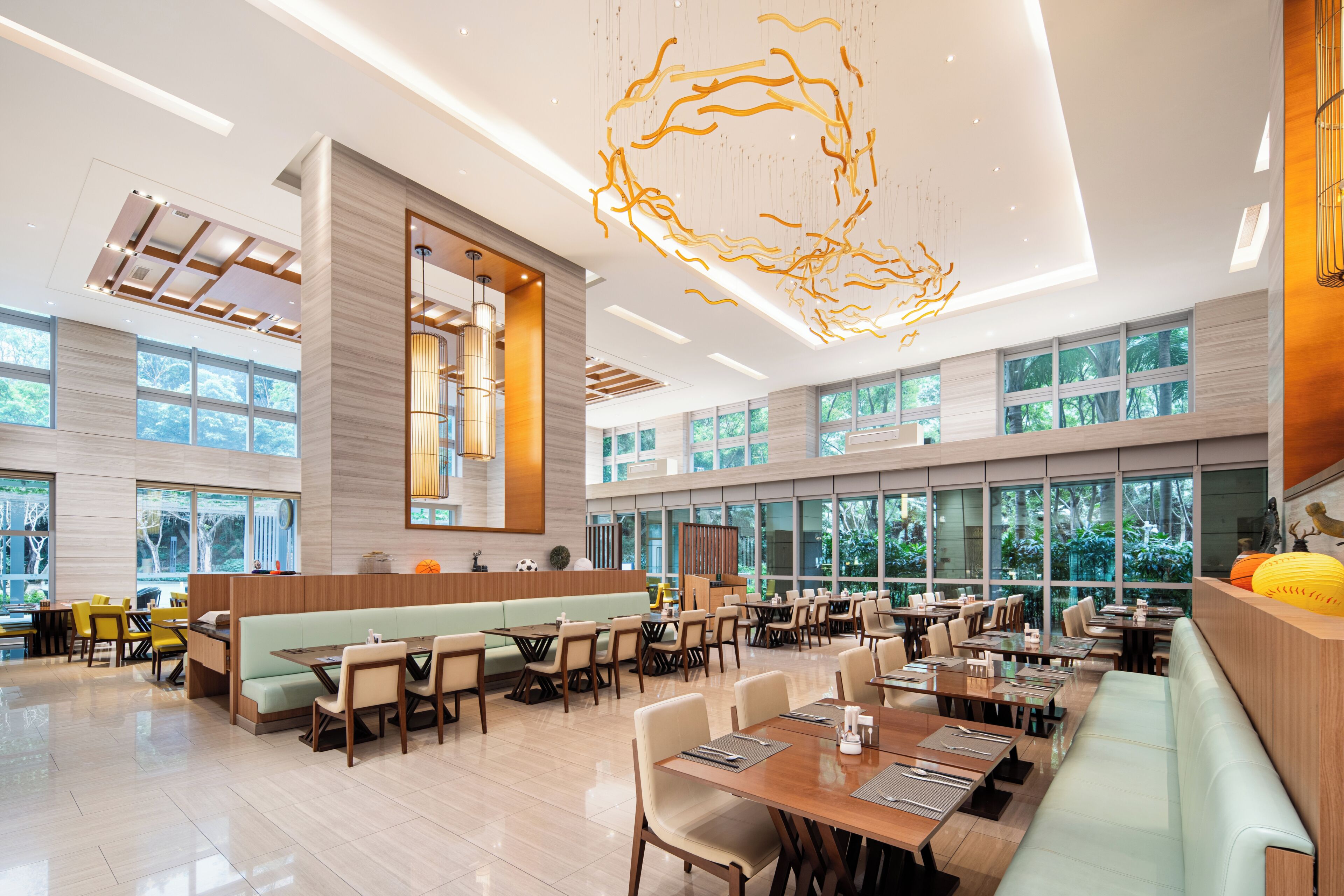 A spacious restaurant with high ceilings, large windows, and modern lighting fixtures.