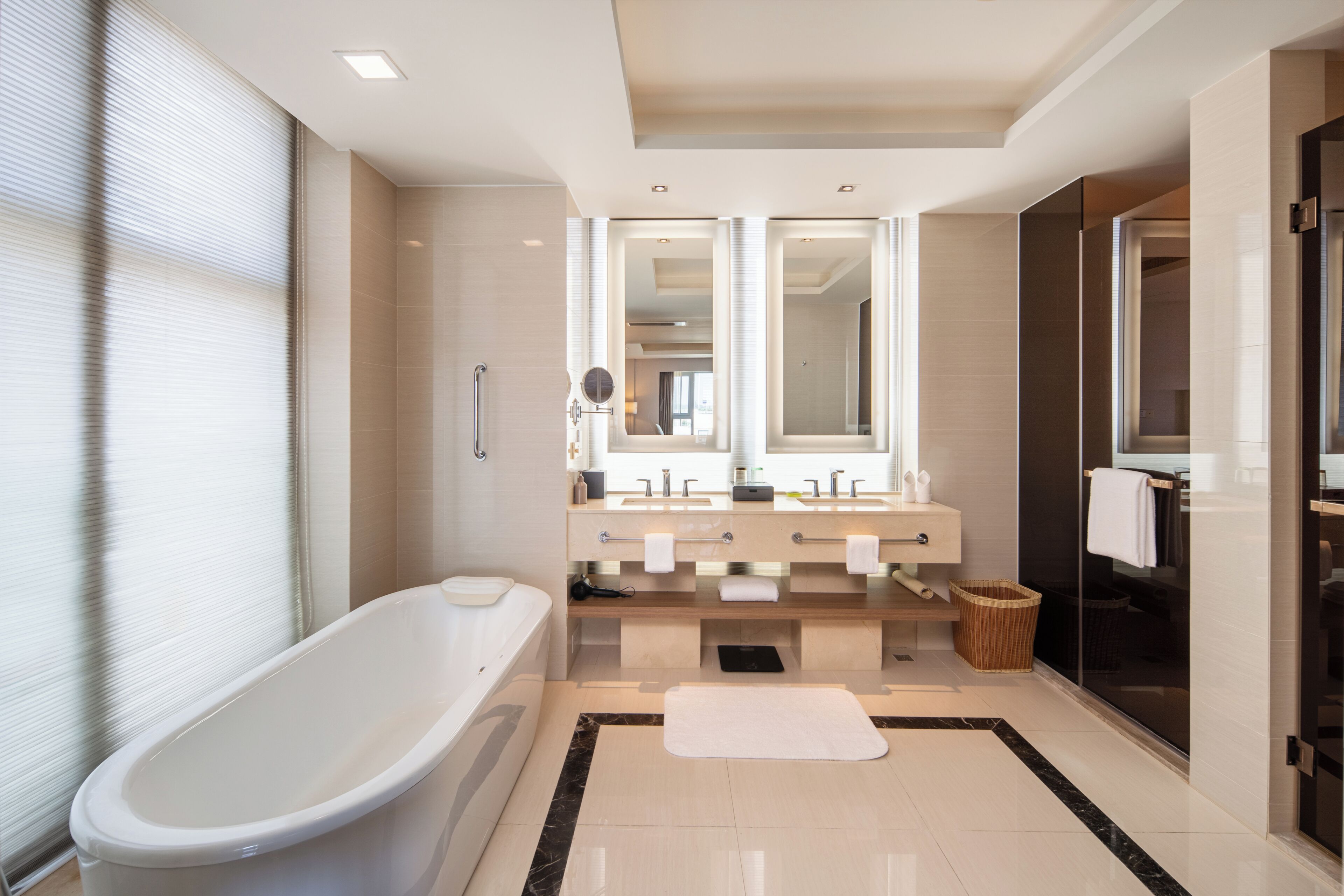 A modern bathroom with a freestanding bathtub, dual sinks, and a large mirror above the vanity.