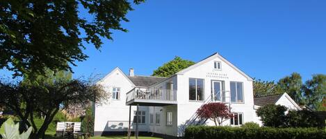 A white two-story building with a balcony, labeled "Stevenson Klint Strand Pension."