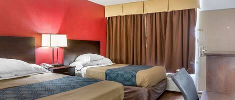 A hotel room with two beds, a nightstand, a lamp, a wardrobe, and a window with curtains.