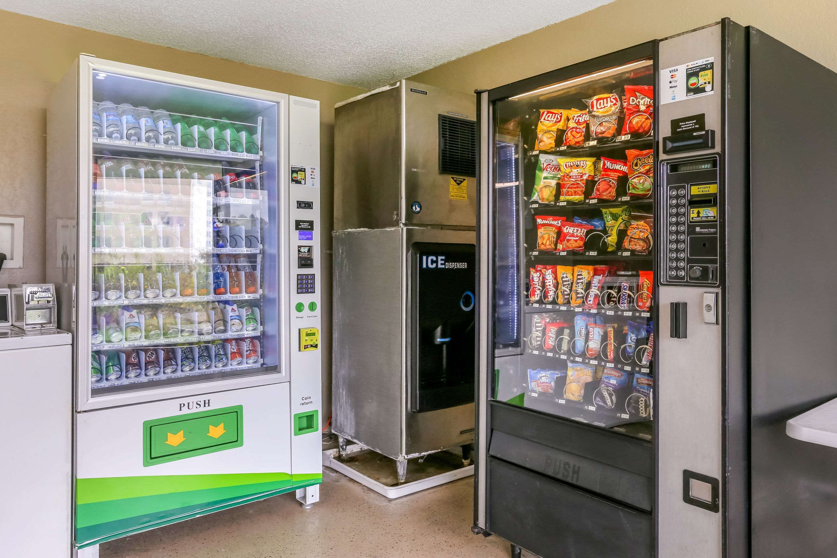 A vending machine area with a beverage dispenser and a snack vending machine.