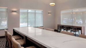 A conference room with a long table, chairs, and large windows.