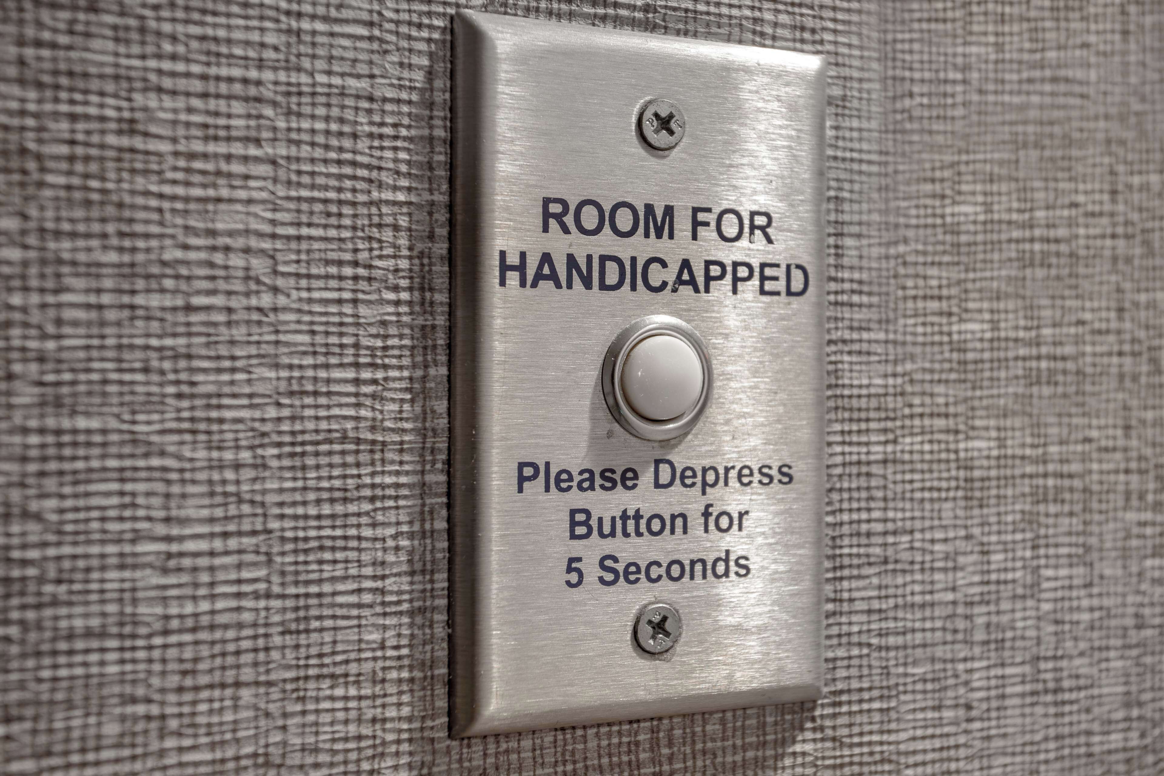 Señal que indica habitación para personas con discapacidad, con un botón para accionar durante 5 segundos.