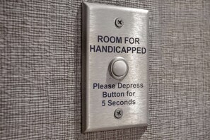 A sign indicating a room for handicapped individuals with a button to depress for 5 seconds. - Homewood Suites by Hilton Lackland AFB/SeaWorld, TX (San Antonio)