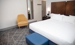 A hotel room with a bed, a chair, a nightstand, and a mirror. - Hampton Inn & Suites Williamsport-Faxon Exit (Williamsport)