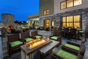 An outdoor patio area with wicker furniture and a built-in fire feature. - Hampton Inn & Suites Williamsport-Faxon Exit (Williamsport)