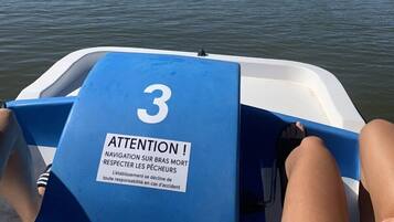 A boat with a blue cover and a warning sign in French.