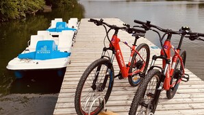 Un muelle de madera con dos bicicletas y un bote.