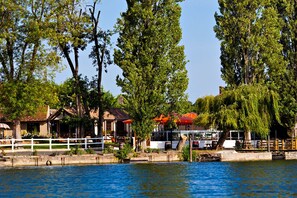 A riverside property with a white fence, a dock, and a building with a red roof. - Les Canisses (Saint-Pierre-la-Garenne)