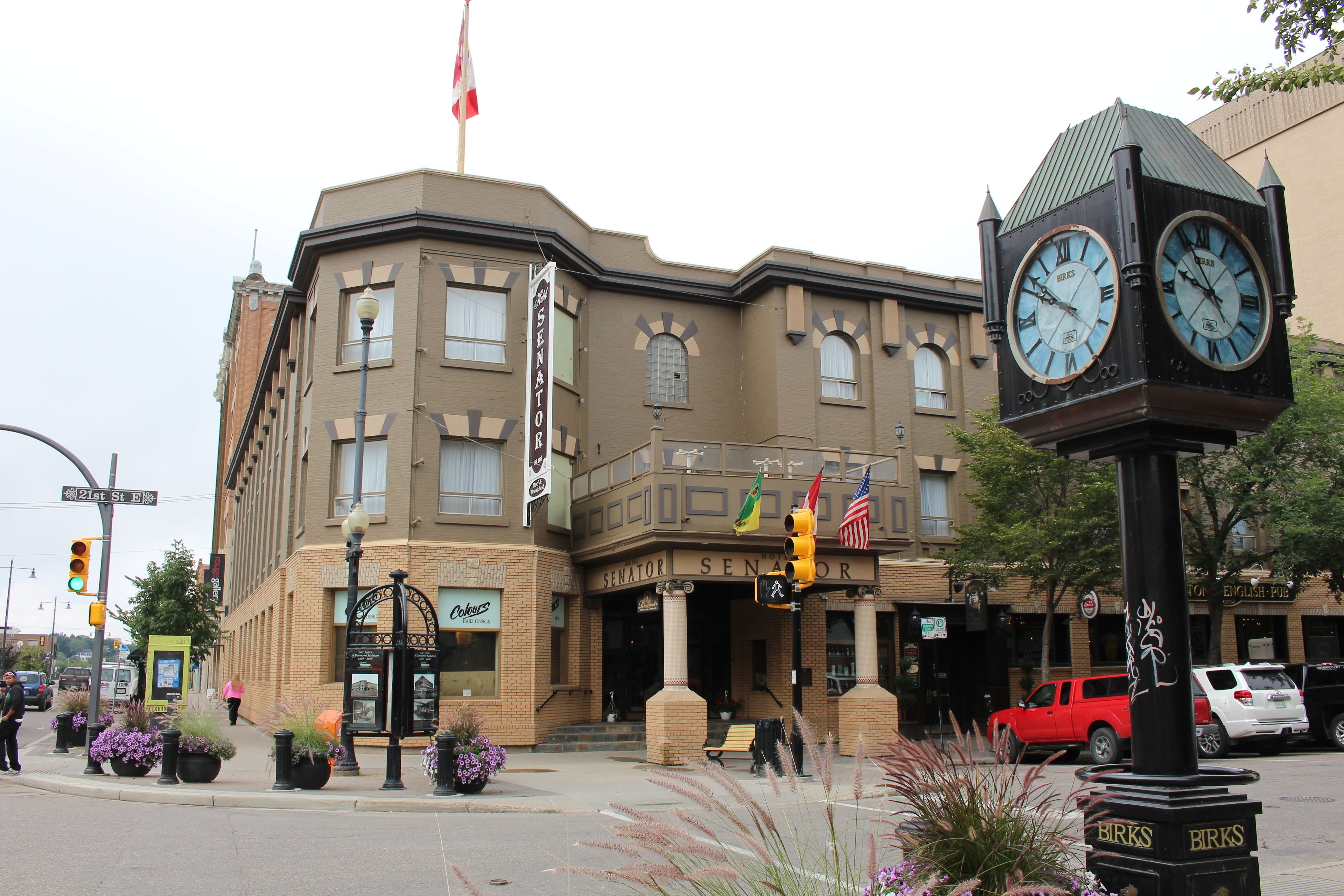 A historic building with a clock tower, a flag, and a sign that reads "SENATOR SENATOR".