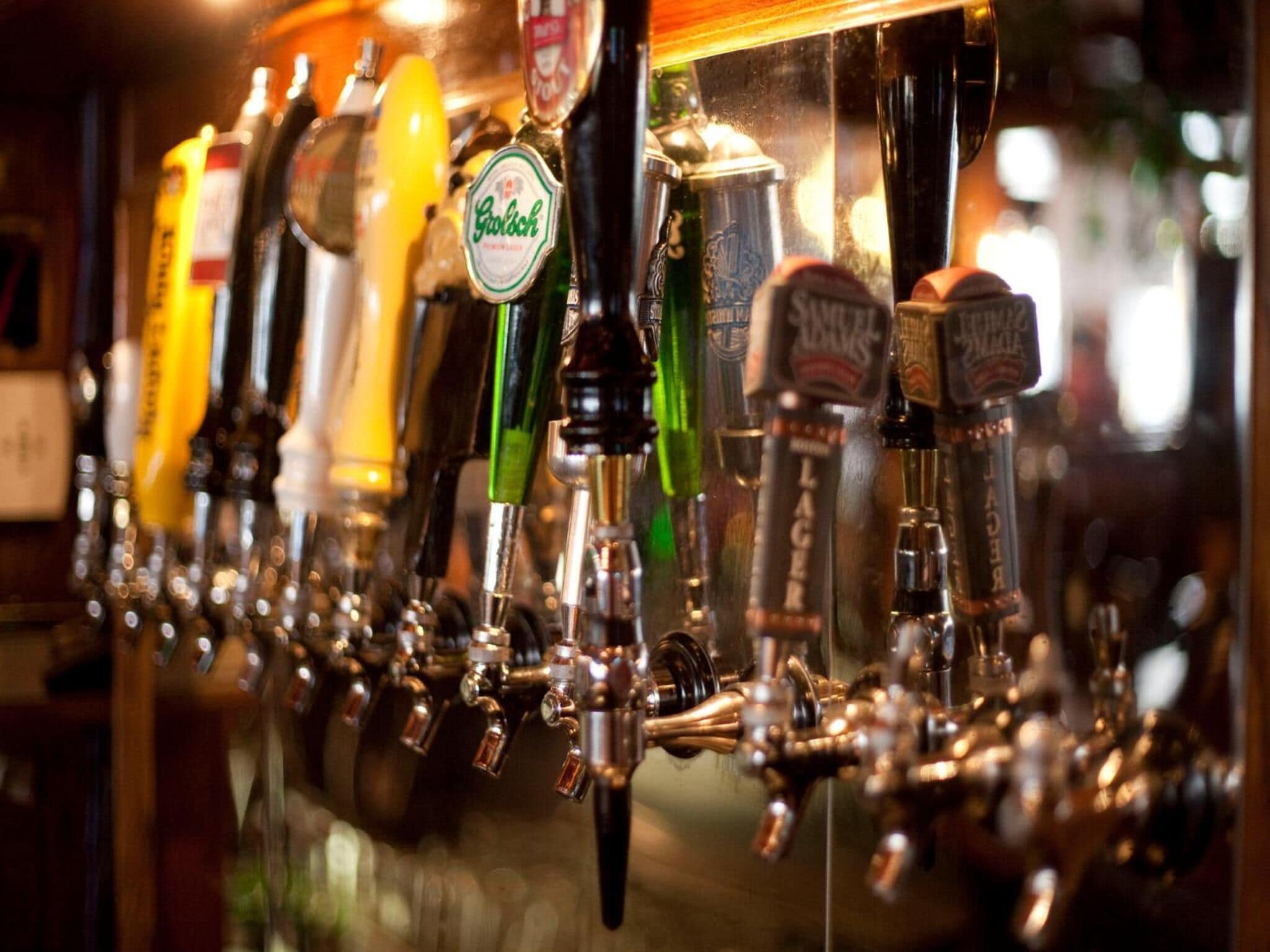 A row of beer taps with various brands visible.