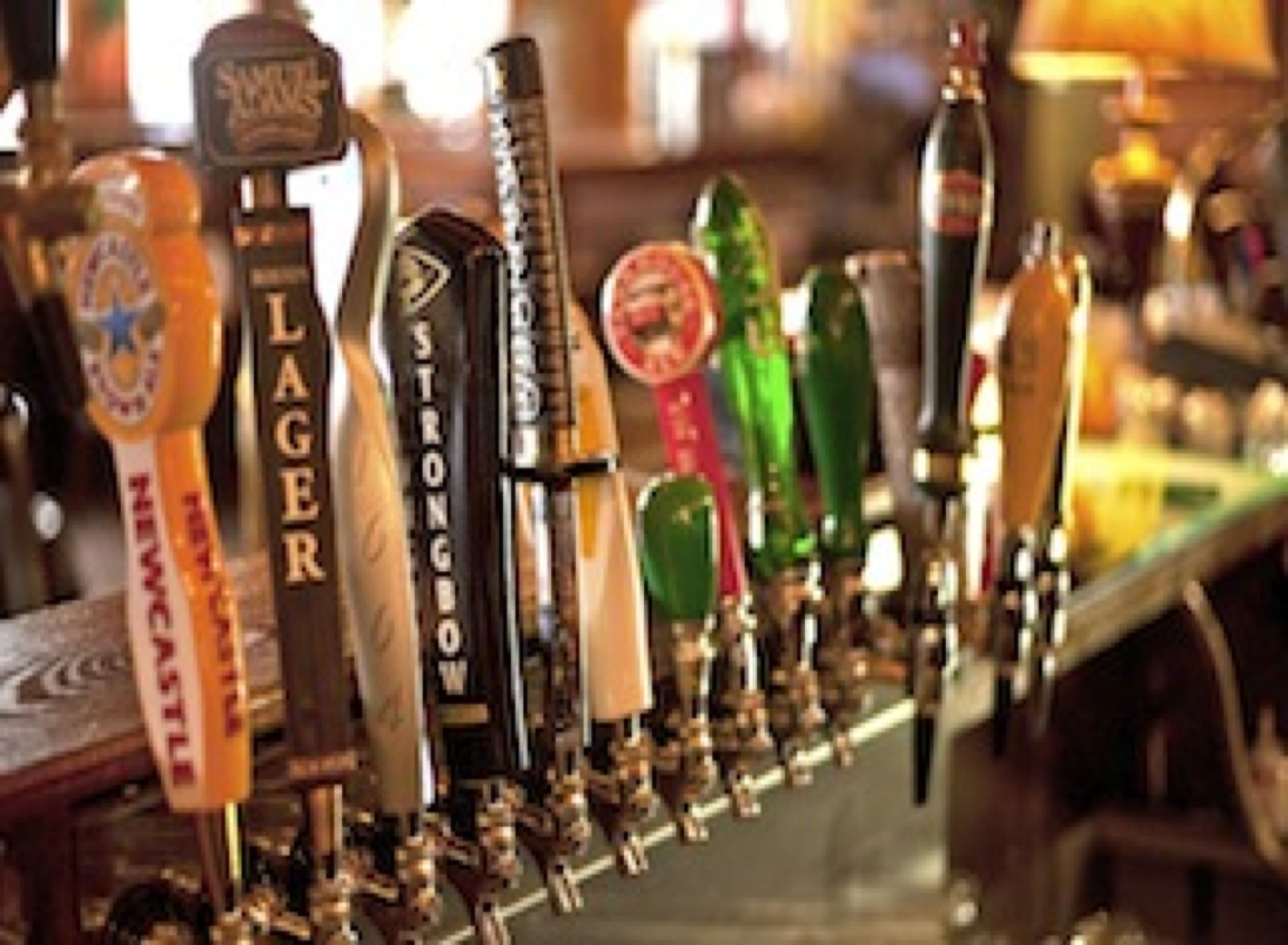 A bar with multiple beer taps, including brands like Newcastle and Strongbow.