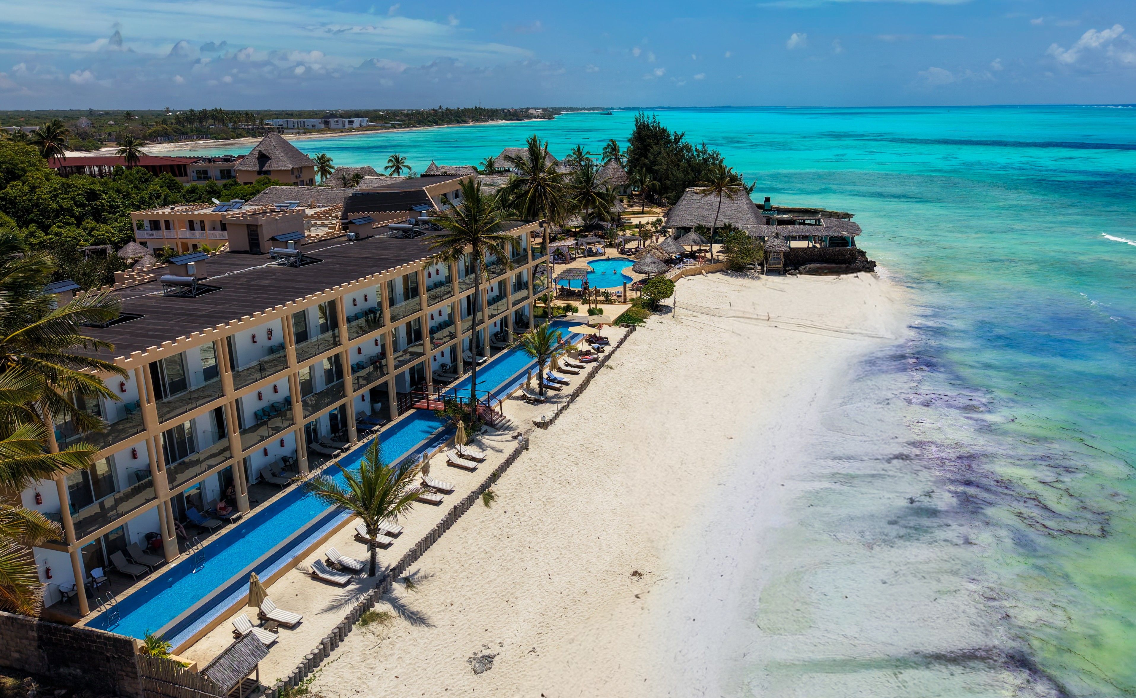 A resort with a pool, beach, and ocean view.