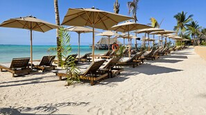 Playa privada, arena blanca, sillas reclinables de playa, sombrillas