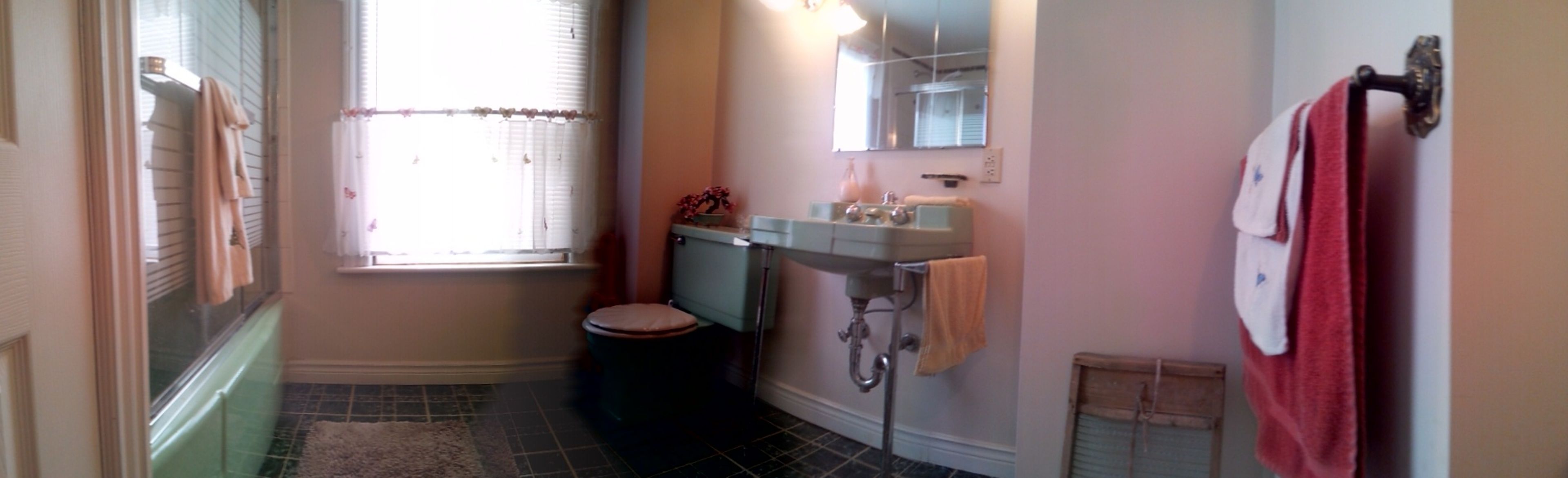 Une petite salle de bain comprenant des toilettes, un lavabo et une fenêtre.