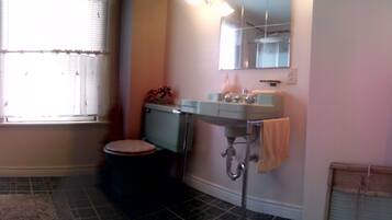 A compact bathroom with a toilet, sink, and window.
