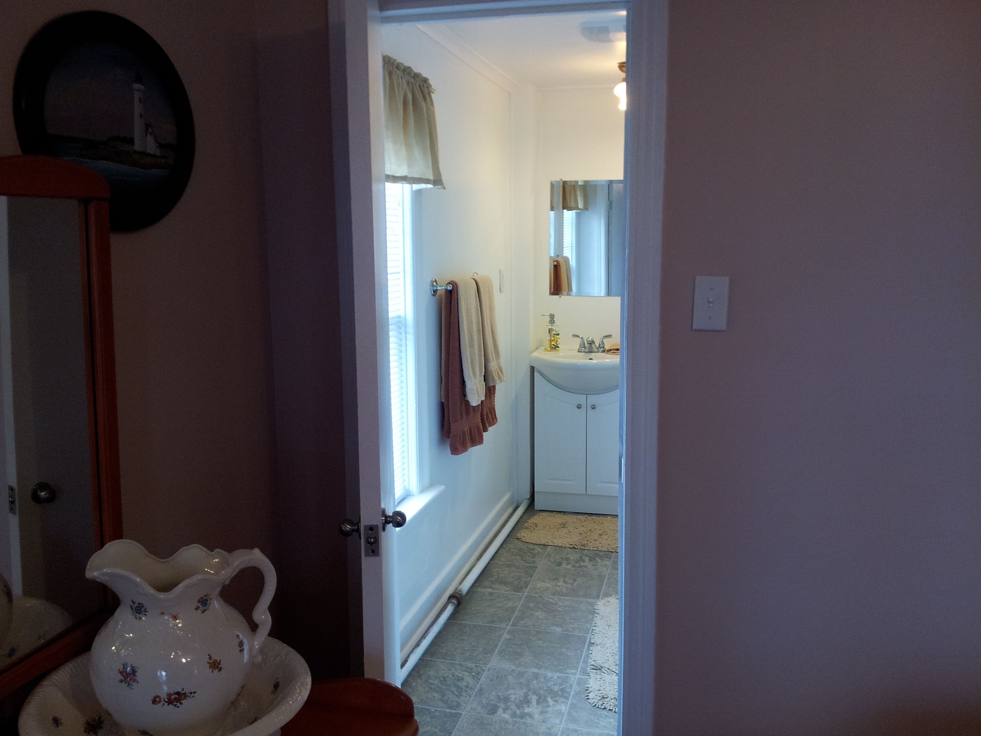 Un bagno con lavabo, specchio e porta asciugamani.