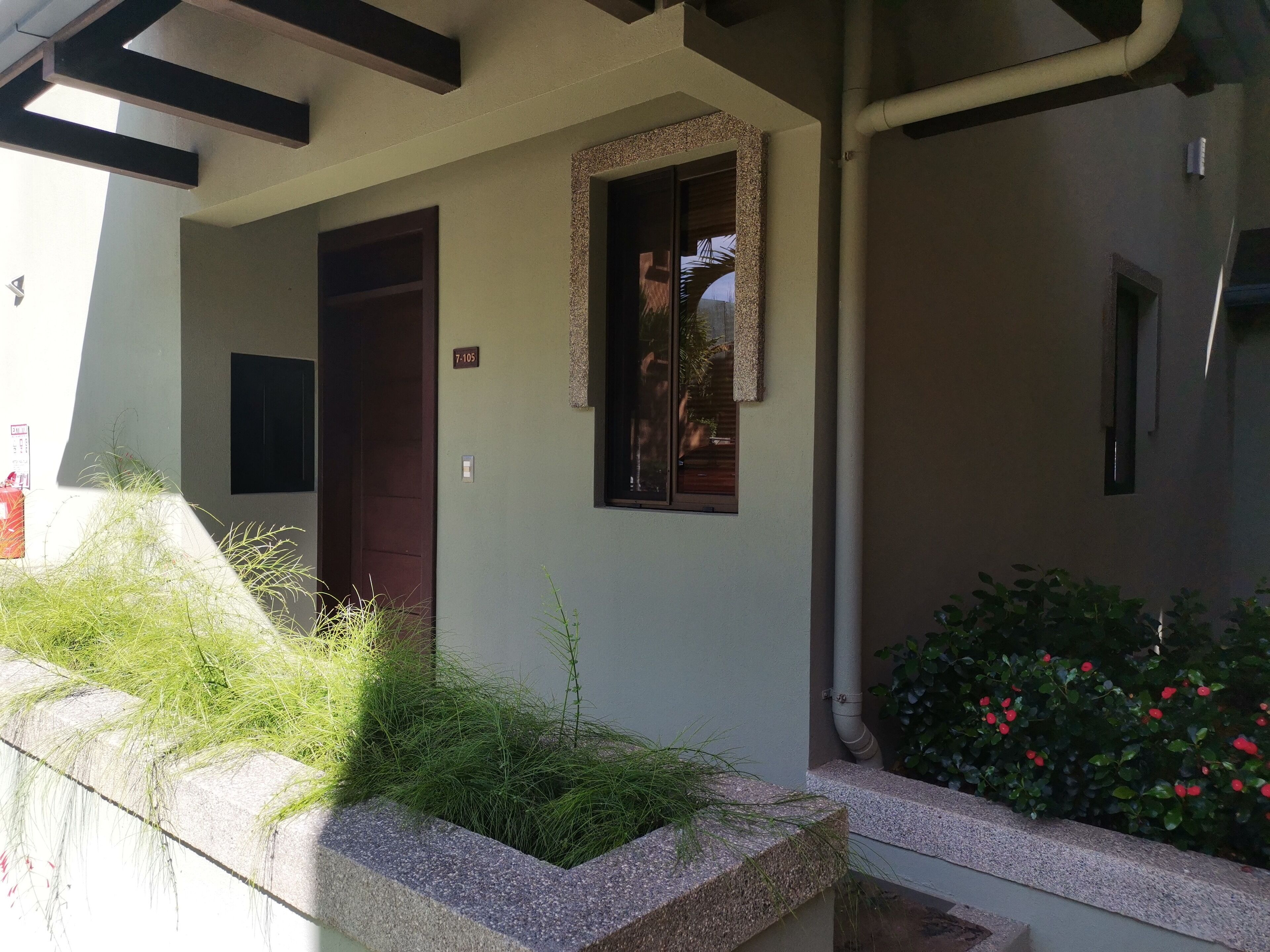 Ingresso di un edificio con una porta, una finestra e un piccolo cartello.