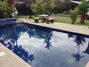 Piscina com superfície de água cristalina refletindo árvores ao redor.