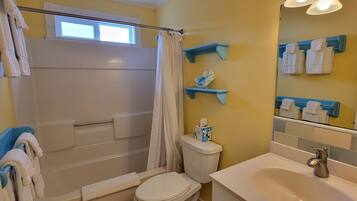 Une salle de bain équipée d’une douche, de toilettes, d’un lavabo et de porte-serviettes.