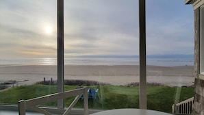 A view from a balcony overlooking a beach with a clear sky. - Sea Sprite at Haystack Rock (Cannon Beach)