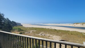 A beach with a wooden deck in the foreground. - Sea Sprite on the Estuary (Cannon Beach)