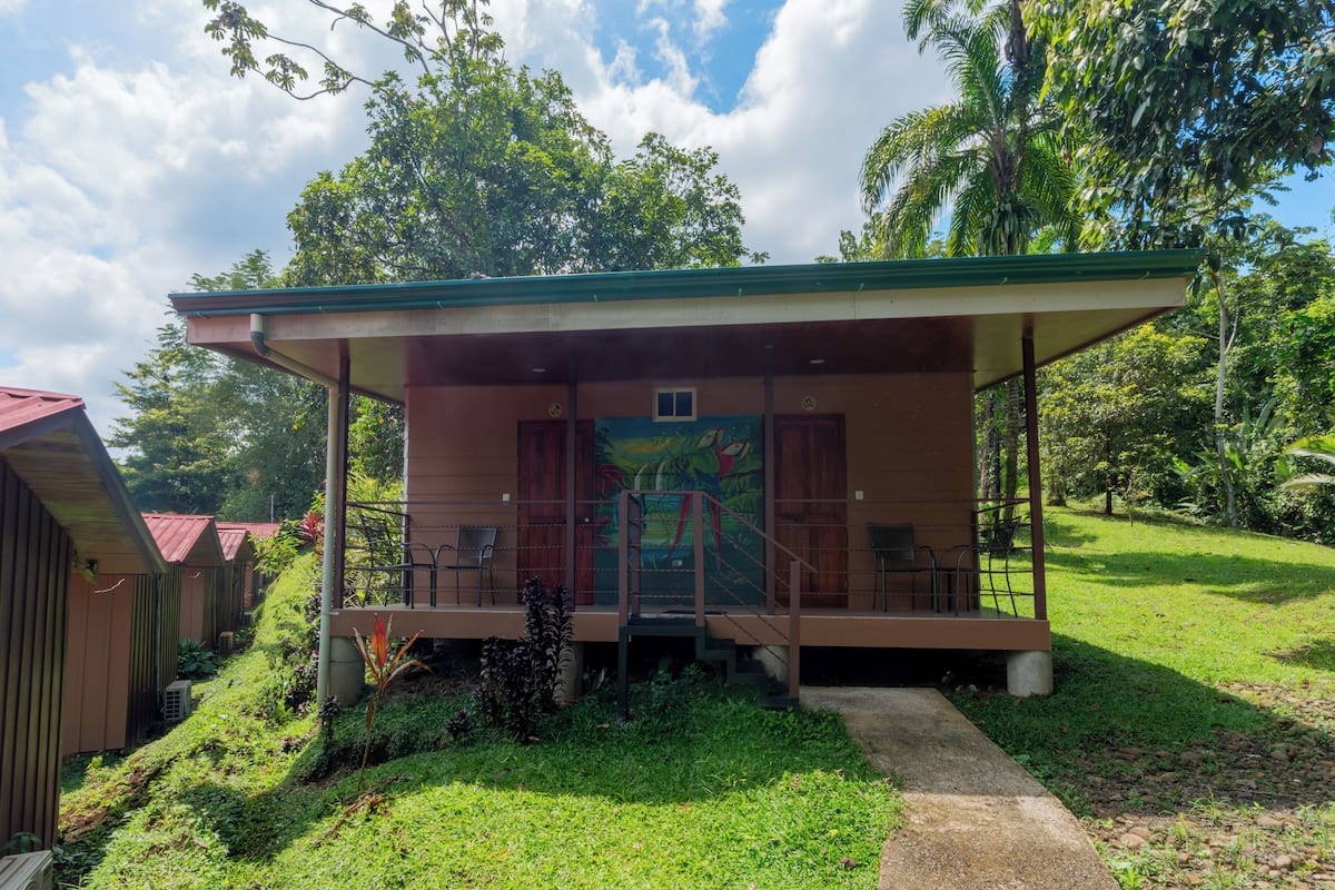 A small, single-story building with a covered porch and a mural on the wall.