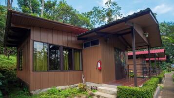 A wooden building with large windows, a fire extinguisher, and a covered porch.