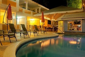 Alberca al aire libre, sombrillas en la alberca y camastros 