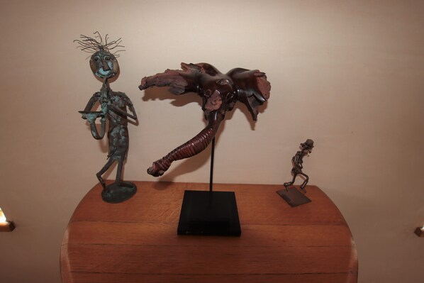 A wooden table with three metal sculptures.