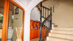 Un escalier avec une rampe noire menant à un palier.