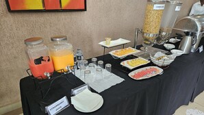 A buffet table with various food and drink options, including jars of orange juice and a sign for strawberry juice. - Bridgeview Hotel & Conference Centre (Lilongwe)