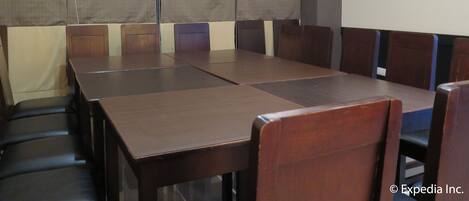 A conference room with a long table and multiple chairs.