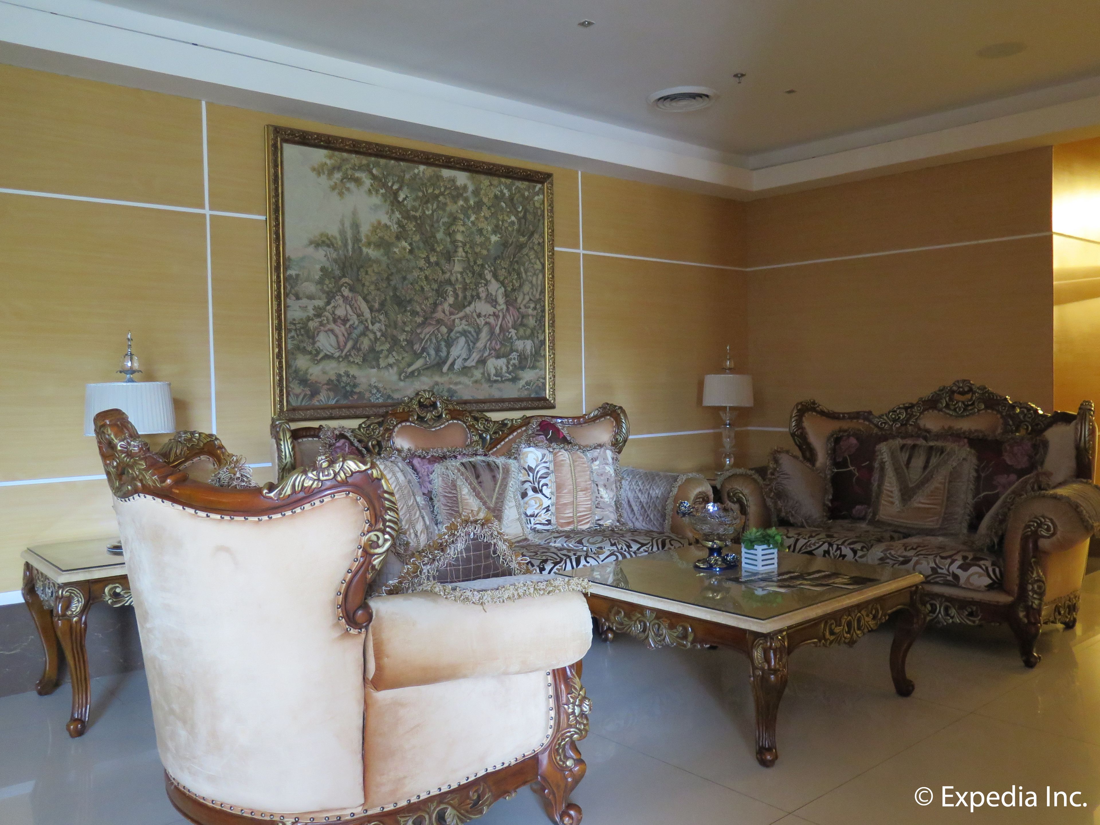 Una habitación tradicional con muebles ornamentados, un cuadro grande enmarco y una araña.