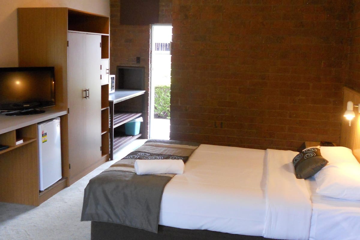 Un dormitorio con cama, televisión y armario.