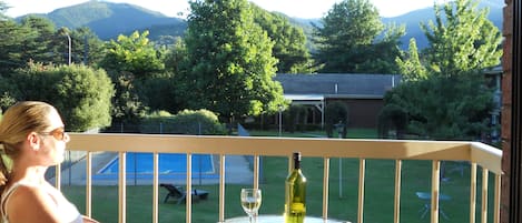 Un balcon avec une table, une bouteille de vin et un verre de vin.