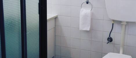Un baño pequeño con inodoro, lavabo y un perchero para toallas.