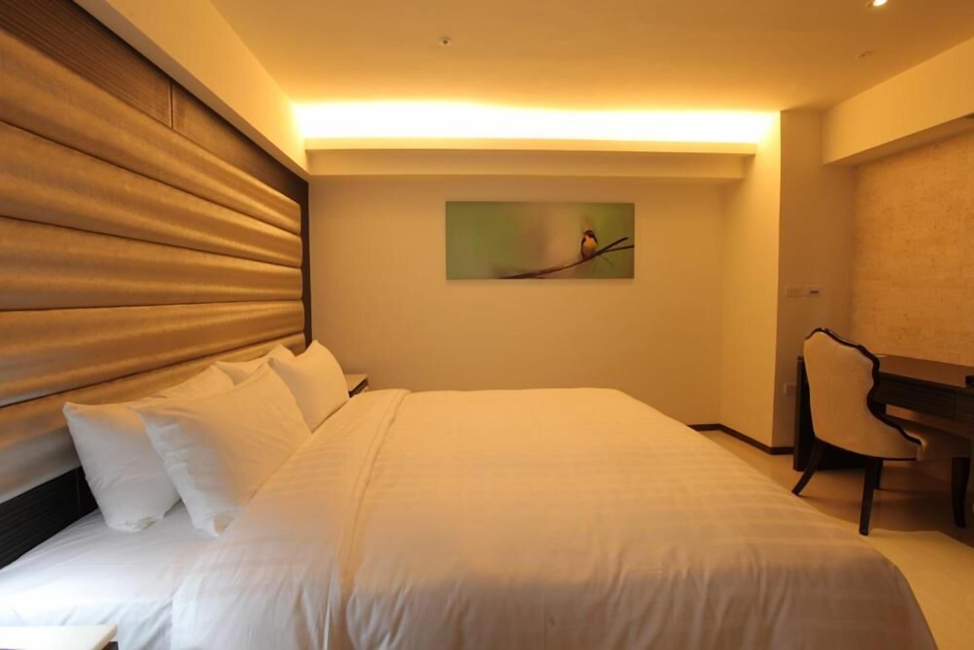Une chambre d ’hôtel avec un grand lit, un bureau et une chaise.
