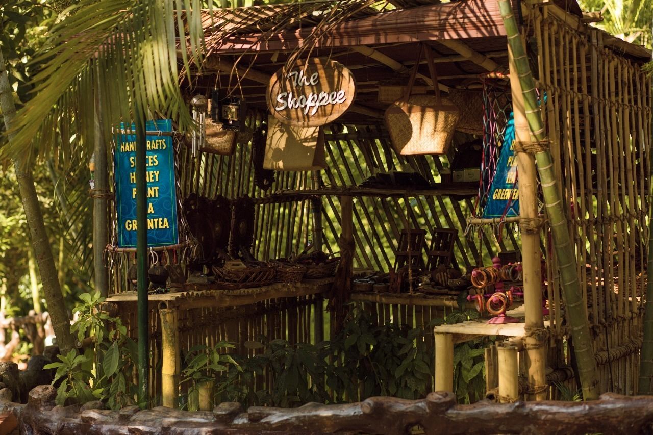 A rustic bamboo structure with a sign reading "The Shoppee."