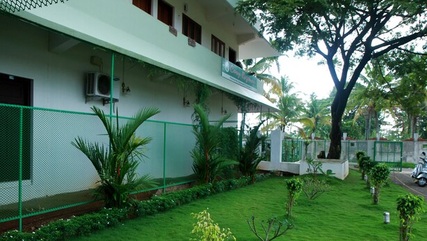 A building with a green lawn, a tree, and a fence. - Cosy Regency (Ambalapuzha)